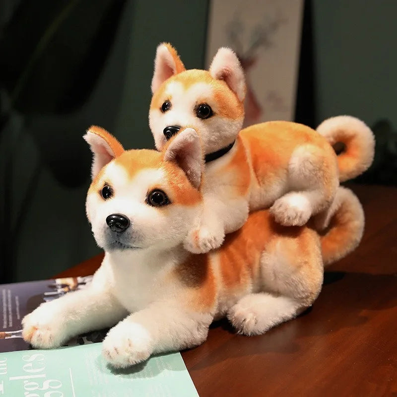 Two plush Shiba Inu dogs stacked on top of each other on a wooden surface.