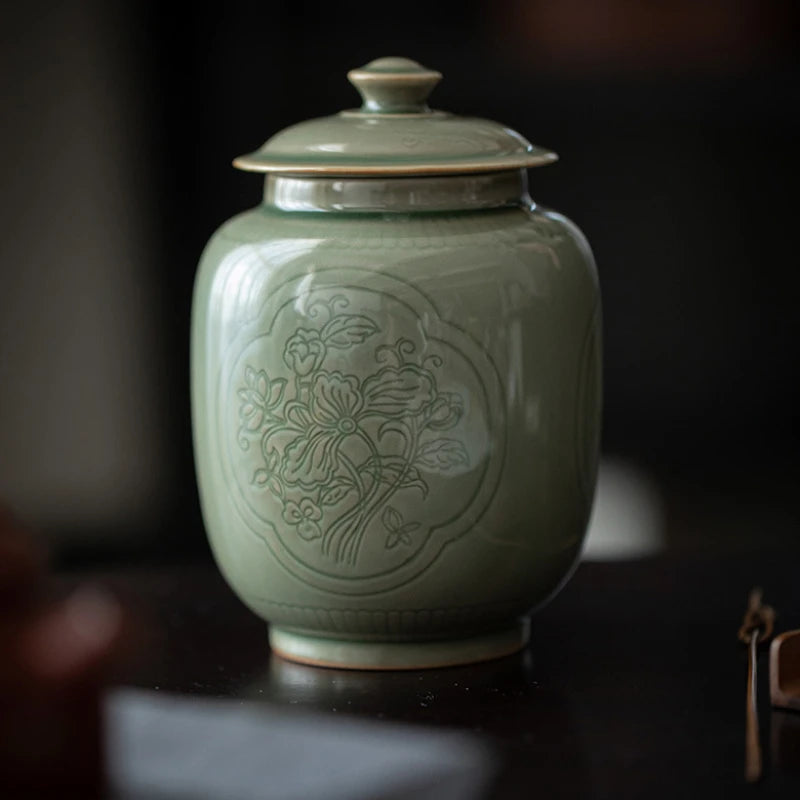 Green ceramic jar with floral patterns on a dark background